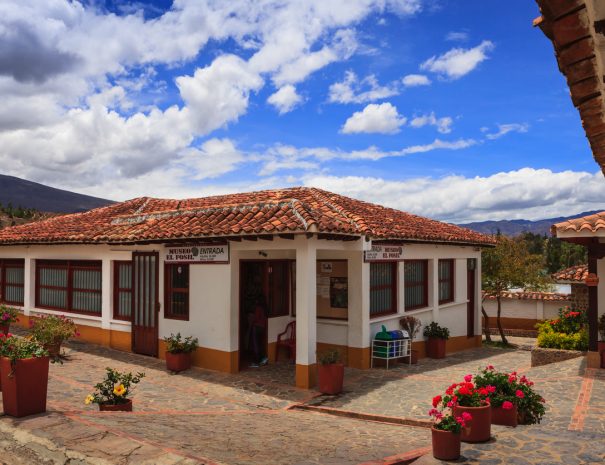 Moniquirá, Colombia - September 14, 2014:  The Museo El Fósil in Moniquirá near the town of Villa de Leyva, Boyaca, in the South American country of Colombia. The museum, has been constructed over the 110 Million year old Kronosaurus fosil found by a local peasant in 1977.  The area was covered by shallow inland seas in the Cretaceous period; it is now at an elevation of over 7000 feet above sea level. The converging and exploding lines in the photo, make it interesting. In the background, the always present Andes Mountains. Blue skies with white clouds complete the picture. Photo shot in the morning sunlight; horizontal format. Copy space.