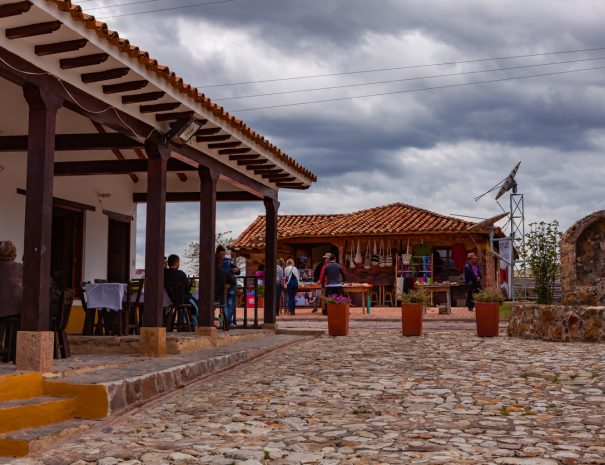 Moniquirá, Colombia - September 14, 2014: handicraft shops selling bags, hats, Ponchos etc., near the Museo El Fósil in Moniquirá near Villa de Leyva in the Department of Boyaca of the South American country of Colombia. To the left are some restaurants. The sky is overcast and it will probably rain shortly. Photo shot in the morning sunlight; horizontal format. Copy space. Camera: Canon EOS 5D MII. Lens Canon EF 24-70mm F2.8L USM.