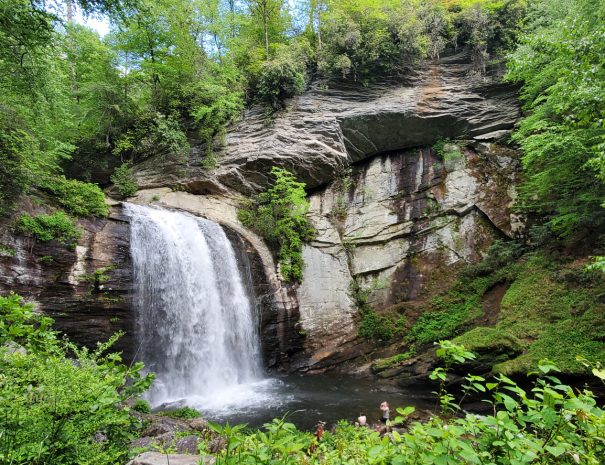 The pristine Looking Glass Falls in the Pisgah National Forest outside of Brevard, NC. This photo was taken in Springtime. Distant onlookers marvel at the size and majesty of the waterfall.